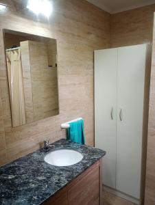 a bathroom with a sink and a mirror at Quincho Coihues in Esquel +27 photos