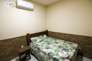 Un dormitorio con una cama y una luz en la pared. en Casa com ar-condicionados e localização perfeita, en Canoa Quebrada