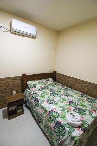 Un dormitorio con una cama con un edredón floral. en Casa com ar-condicionados e localização perfeita, en Canoa Quebrada