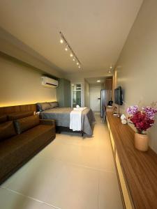 a hotel room with a bed and a couch at Açores Tamandaré Flats By HM in Tamandaré