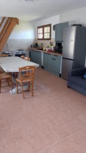 a kitchen with a table and a table and a refrigerator at Maison Normande - Le Mesnil en Ouche in Épinay +17 photos