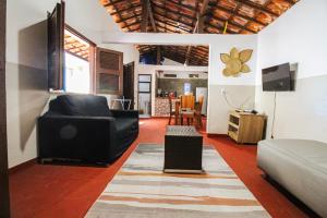 a living room with a couch and a television at Casa Azul - Aconchego na Broadway a Poucos Metros da Praia in Canoa Quebrada