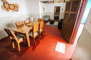 a dining room with a wooden table and chairs at Casa Azul - Aconchego na Broadway a Poucos Metros da Praia in Canoa Quebrada