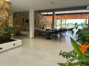 a dining room with tables and chairs and plants at baia kristal paraiso aguas cristalinas in Cartagena de Indias