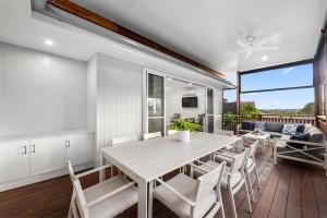 Una cocina y un comedor con una mesa y sillas blancas. en Ellangowan, en Toowoomba