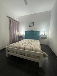 Un dormitorio con una cama con cabecero azul. en Departamento centro, en Fernández