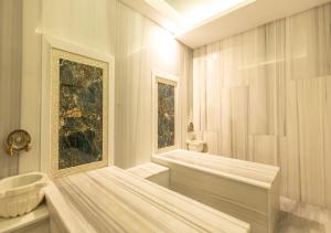 a white bathroom with a tub and a sink at Peramis Hotel & Spa in Antalya