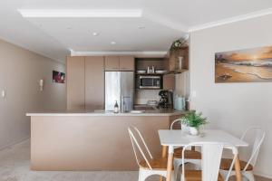 une cuisine et une salle à manger avec une table et des chaises dans l'établissement Cosy Mount Base King Bed Ensuite & Top Location, à Mount Maunganui 26 autres photos