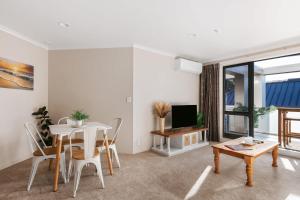 un salon avec une table et une salle à manger dans l'établissement Cosy Mount Base King Bed Ensuite & Top Location, à Mount Maunganui