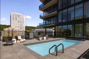 Modern unit with Pool and Gym included في مونتريال: مبنى كبير مع مسبح بجانب مبنى