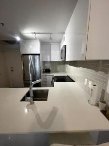 Modern unit with Pool and Gym included في مونتريال: مطبخ بخزائن بيضاء ومغسلة