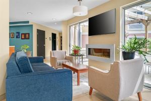 a living room with two blue couches and a tv at Best Western Plus Traverse City in Traverse City