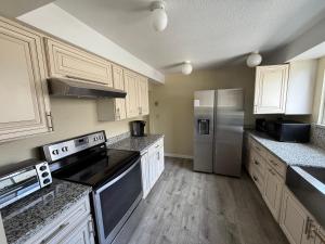 a kitchen with white cabinets and a stainless steel refrigerator at Private Room "Cherry" by UW in Seattle +2 photos