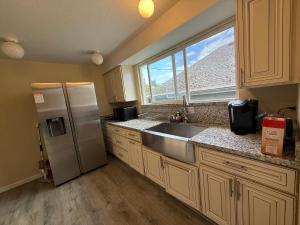 a kitchen with a stainless steel refrigerator and a window at Private Room "Cherry" by UW in Seattle
