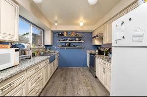 a kitchen with white appliances and a blue wall at Private Room "Cherry" by UW in Seattle