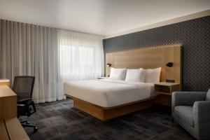 una habitación de hotel con una cama y una silla en Best Western Plus City Centre Centre-Ville, en Quebec