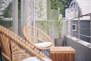 a rattan chair on a balcony with a table at Tsubomi Shibuya in Tokyo