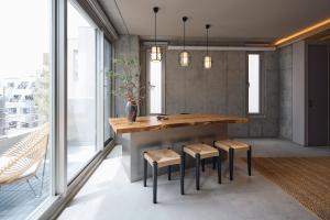 a dining room with a table and stools at Tsubomi Shibuya in Tokyo