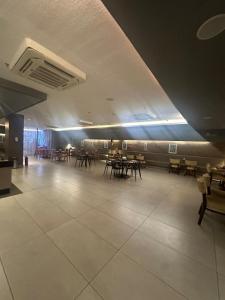ein Esszimmer mit Tischen und Stühlen in einem Gebäude in der Unterkunft Flat Premium Hotel Rãmada in Recife