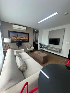 ein Wohnzimmer mit Couch und Flachbildfernseher in der Unterkunft Flat Premium Hotel Rãmada in Recife