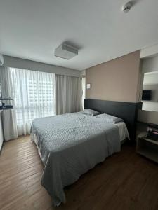 ein Schlafzimmer mit einem Bett und einem großen Fenster in der Unterkunft Flat Premium Hotel Rãmada in Recife
