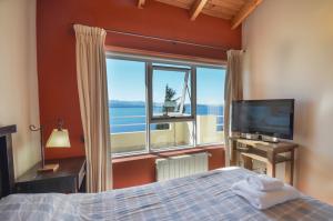 a bedroom with a bed and a large window at Balcones al Nahuel in San Carlos de Bariloche
