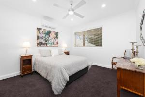 Un dormitorio blanco con una cama y una ventana. en Ellangowan, en Toowoomba