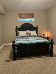 Un dormitorio con una cama con marco de cama negro. en Rooms for Hosting, en Calgary 14 fotos más