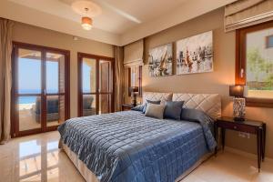 Un dormitorio con una cama con un edredón azul. en Aphrodite Hills Mythos Collection Villa Iris Private Pool Sea View 5 Bedrooms Paphos, en Paphos 9 fotos más