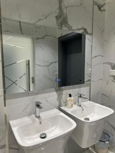 a white bathroom with a sink and a mirror at Home apartment 2 in Medina +10 photos