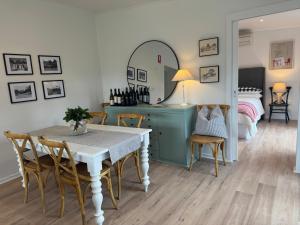 a dining room with a table and a bed at Tweedies Gully Estate Settlers Cottage Barossa in Williamstown