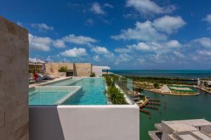 カンクンにあるLuxury Condo of 4 Bedroomsの海を背景にしたスイミングプールの景色を望めます。