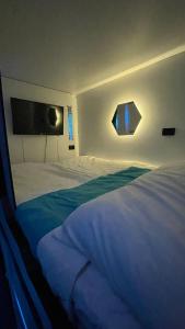 Un dormitorio con una cama grande con dos ventanas. en Hotel Cápsula Bogotá Castellana, en Bogotá