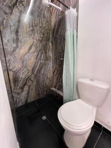 un baño con inodoro y ducha en Hotel Cápsula Bogotá Castellana, en Bogotá