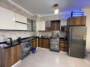 a kitchen with a refrigerator and a washer and dryer at Gaia - Ras Elhekma- Notth coast in Zāwiyat al ‘Awwāmah