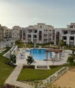a large swimming pool in a city with buildings at Gaia - Ras Elhekma- Notth coast in Zāwiyat al ‘Awwāmah