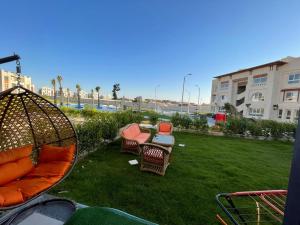a patio with chairs and a table in a yard at Gaia - Ras Elhekma- Notth coast in Zāwiyat al ‘Awwāmah
