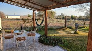 a patio with a table and chairs under a pergola at Casa de campo - PetFriendly in Concepción del Uruguay