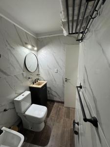 Un baño con inodoro, lavabo y espejo. en BuenosAiresApart, en Buenos Aires
