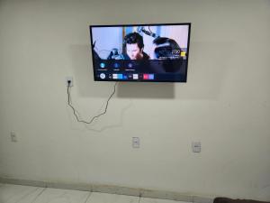 a flat screen tv hanging on a white wall at Pousada Flor do Caribe in Rio das Ostras