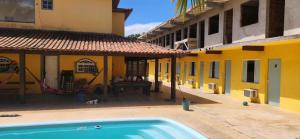 a swimming pool in front of a building at Pousada Flor do Caribe in Rio das Ostras