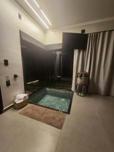 a bathroom with a swimming pool in a room at Angatu Chalés in Serra Negra