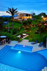 a resort with a swimming pool at night at Finca Hotel Loma Verde in Quimbaya +53 photos