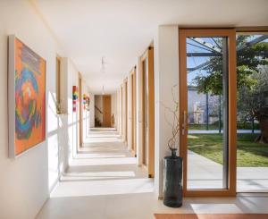 un corridoio interno di un edificio con porte in vetro di Spectacular Brac Villa Villa Adriatic 5 Bedrooms Stunning Sea Views & Infinity Pool & Private Gym Skrip a Supetar (San Pietro di Brazza) Altre 32 foto