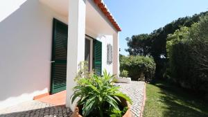 a white house with green shutters and a garden at Beautiful Portuguese Villa Casa Das Buganvillas 3 Bedrooms Close To Praca Private Pool Vale Do Lobo in Vale do Lobo