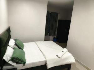 a bedroom with a bed with green and white pillows at Hotel Metro in Guwahati