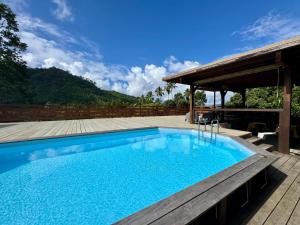 a large swimming pool with a wooden deck at Inake Lodge in Atuona