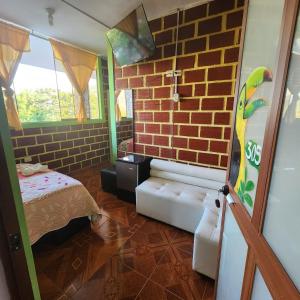a room with a bed and a brick wall at El Encanto de Las Marias in Satipo