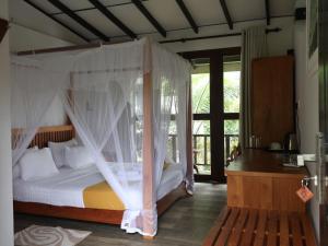 a bedroom with a bed with mosquito nets at Handagedara Resort & Spa in Mirissa