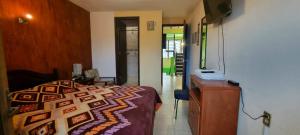 a bedroom with a bed and a desk with a phone at Hotel EL EDEN 2 personas 9 in Cedro